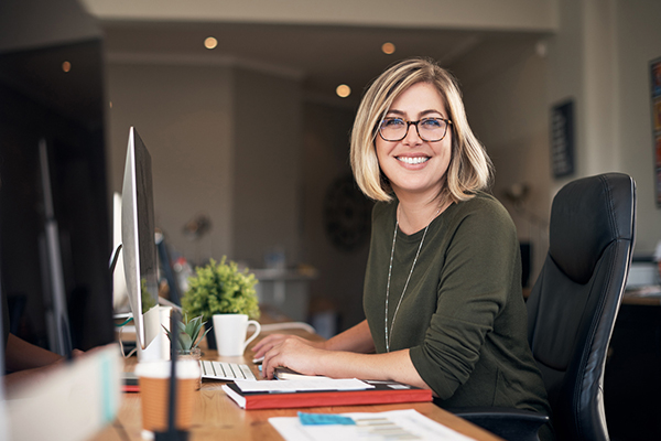 Young woman smiling at working at a computer