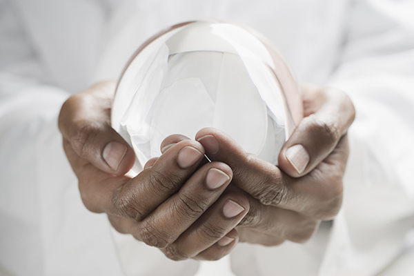 Close up of man holding crystal ball, Getty