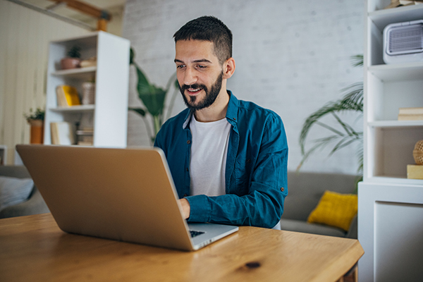 A man on a laptop looking at AIM stocks