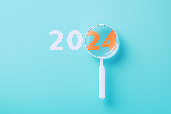 White magnifier over orange 2024 on blue background.