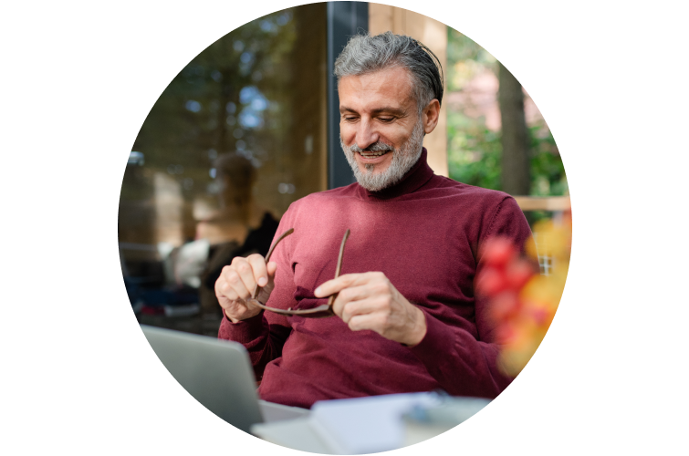 Happy man holding glasses and looking at laptop