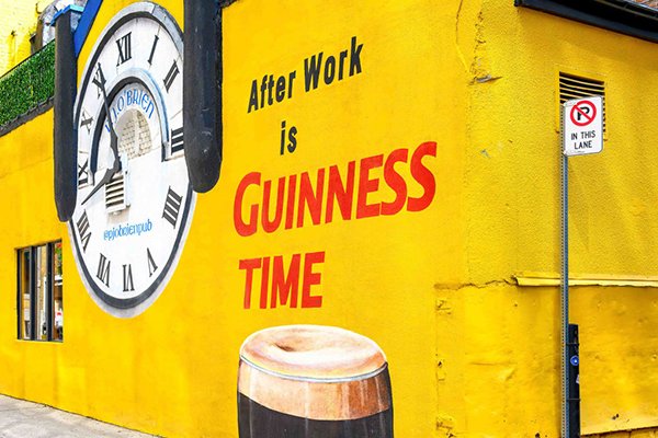 Advert for Guinness beer on a yellow wall, Getty