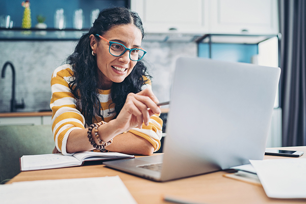 Smiling middle-aged woman working at home on a laptop