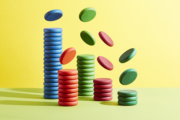 Five stacks of coloured coins with more coins falling on to them, Getty