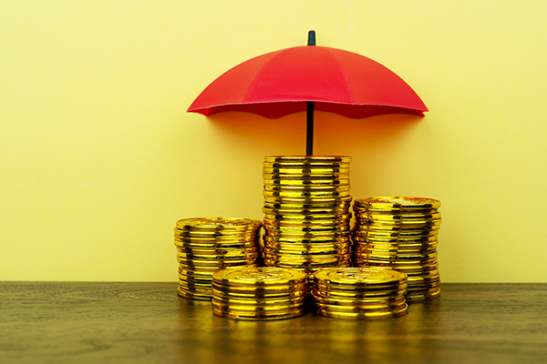 Gold coins under a red umbrella, Getty