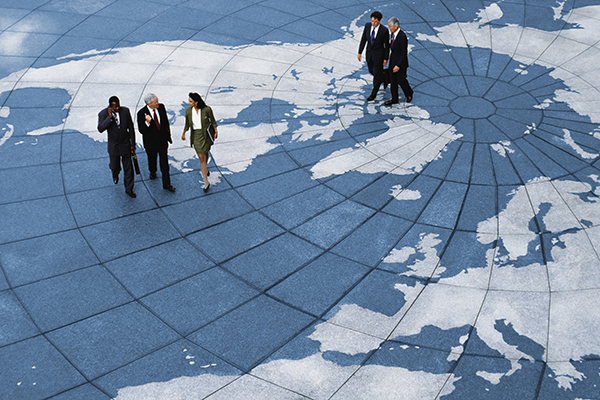 Fund managers walking on large map, Getty
