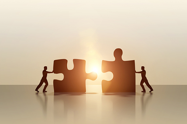 Two men connecting jigsaw pieces