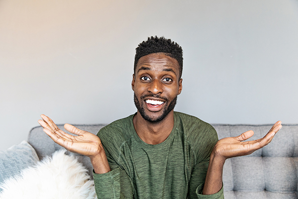 Uncertain young man shrugging, Getty