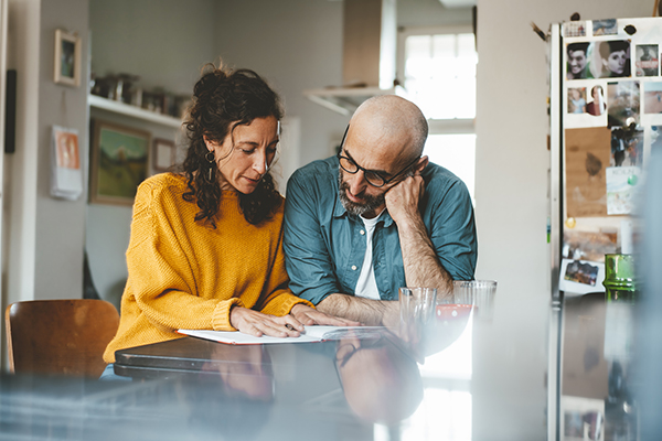 Couple considering their finances in the kitchen, Getty