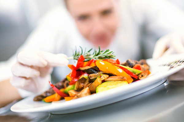 Female chef adding garnish to a dish