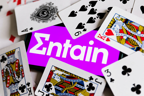 Entain logo surrounded by playing cards, Getty