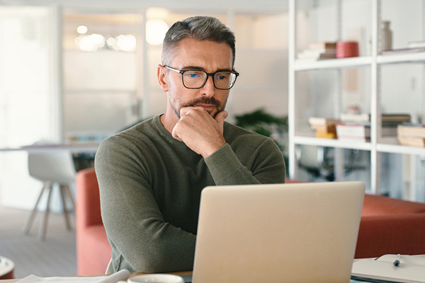 Man sitting in front of laptop thinking