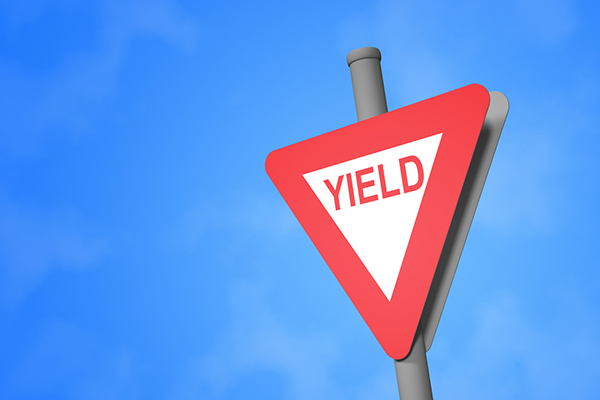 A yield sign against blue sky