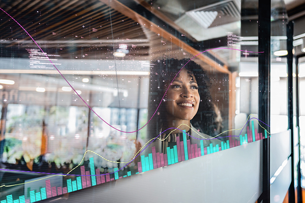 Female investor looking at data visualizations on glass wall