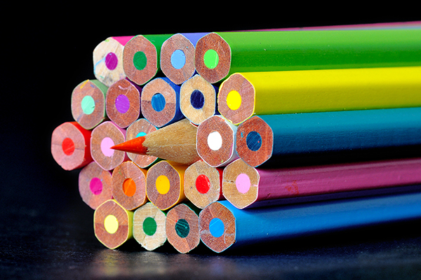 Coloured pencils with one pointing a different way