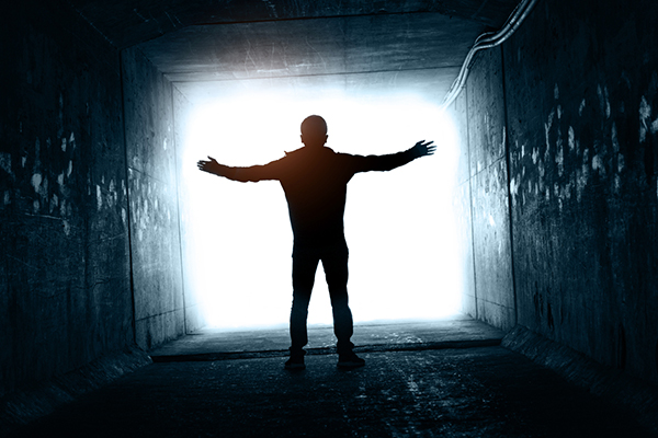 Man walking to the end of the tunnel exit