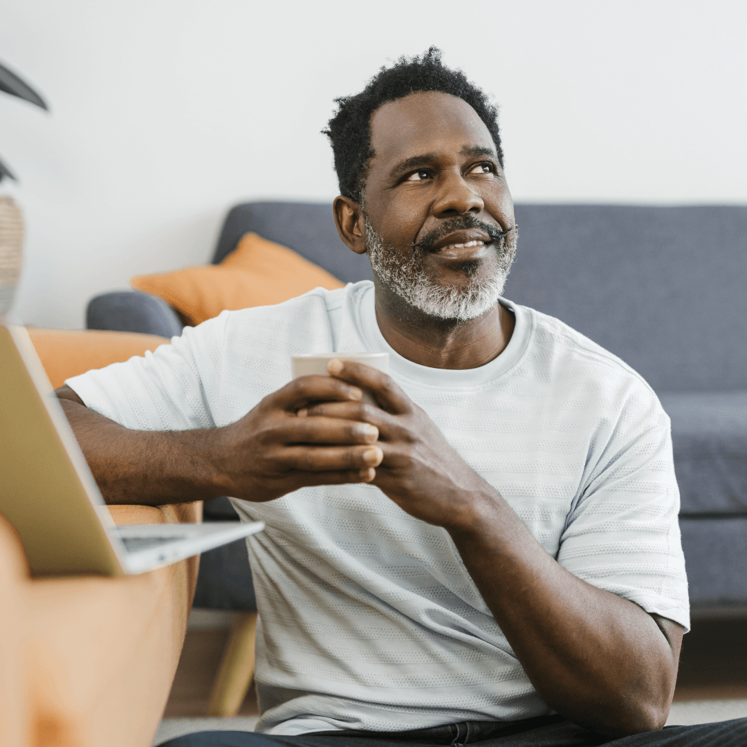 An image of a man on his laptop, looking thoughtful.
