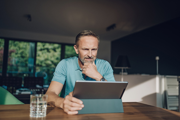 Man sitting at table with a digital laptop