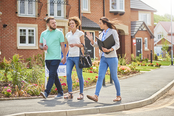 Couple with saleswoman on a new housing development
