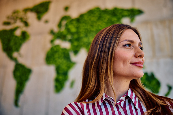 Woman looking sideways in front of world map