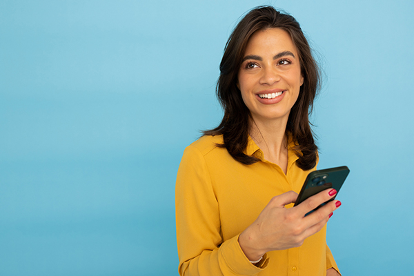 A smiling AIM investor looking at stocks on her phone