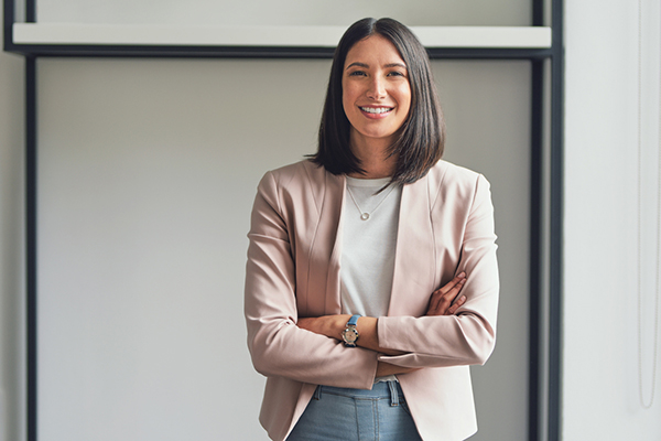 Smiling young woman with arms folded
