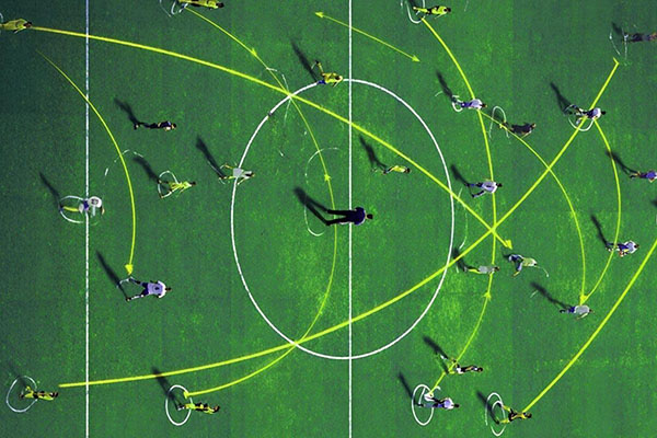 Finimize green football field with players on it