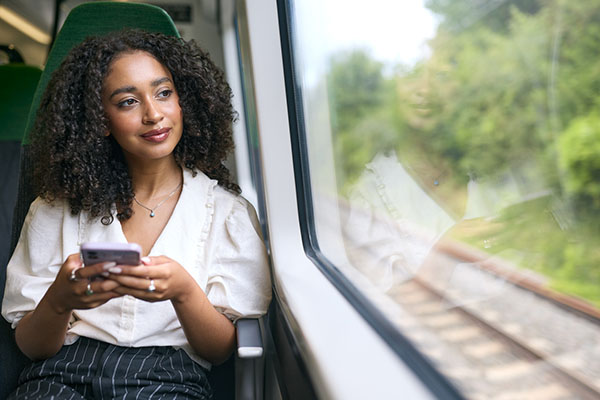 A woman looking on her phone while on a train journey