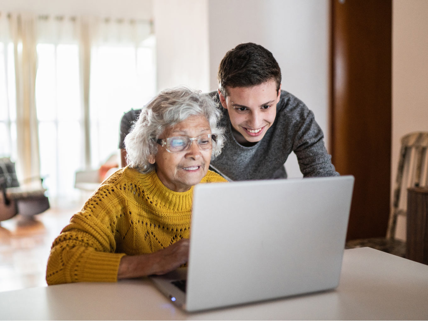 Grandson helps his grandmother with laptop