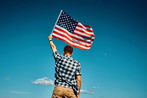 Man holding US flag aloft