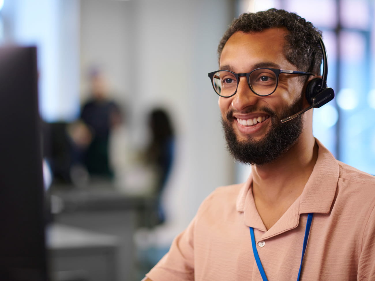 Customer service agent smiling and wearing a headset
