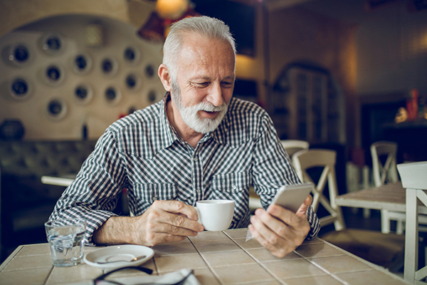 Man drinking coffee while looking at phone article on fund and trust tips