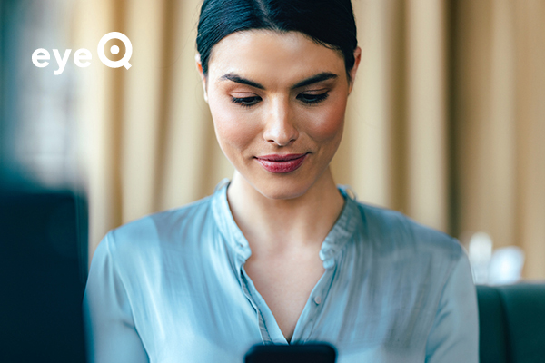 eyeQ Woman smiling and looking at phone