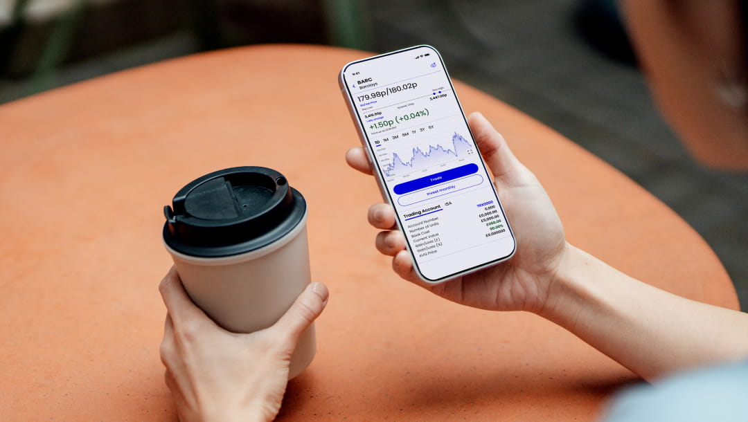 holding phone with coffee outdoors shares