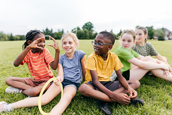 A group of children sitting on grass