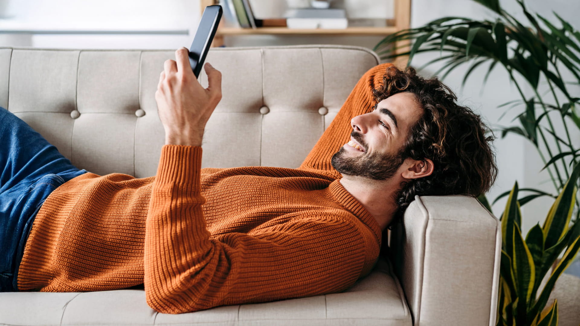 man lies on the sofa looking at smartphone thinking why choose the ii sipp