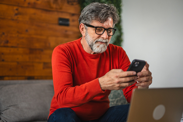 Investor on sofa with smartphone