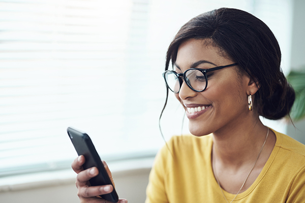 Woman smiling and reading article on phone