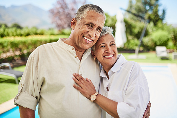 Couple smiling by a swimming pool