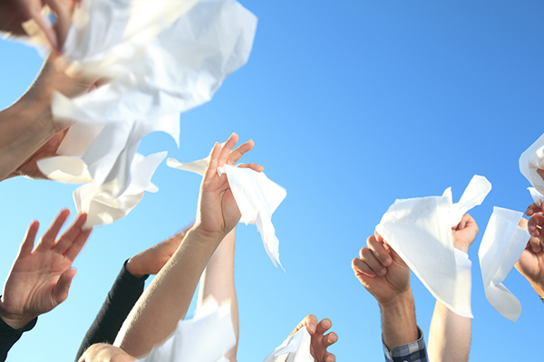 Hands waving goodbye holding tissues