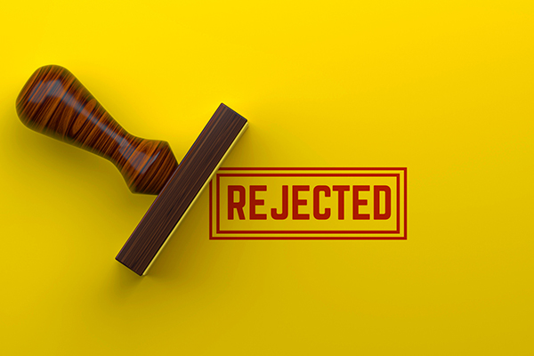 Red stamp saying 'rejected' on yellow paper