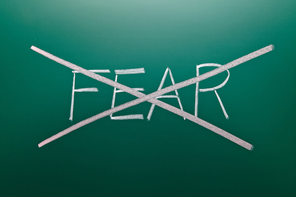 Chalkboard with the word 'fear' crossed out
