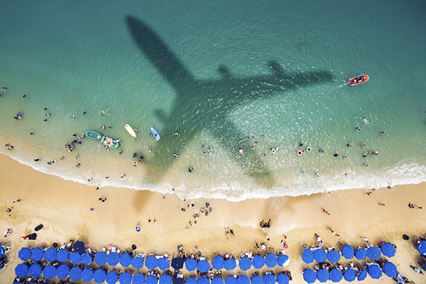 Airplane's shadow over a crowded beach