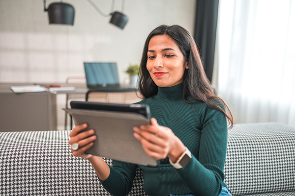 Woman reading tablet computer and smiling