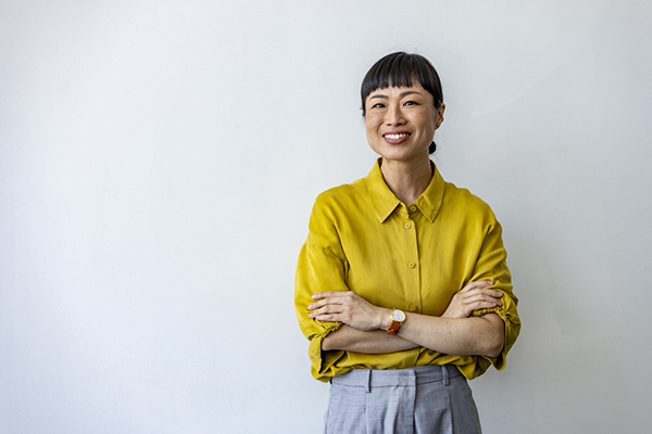Woman in yellow with folded arms