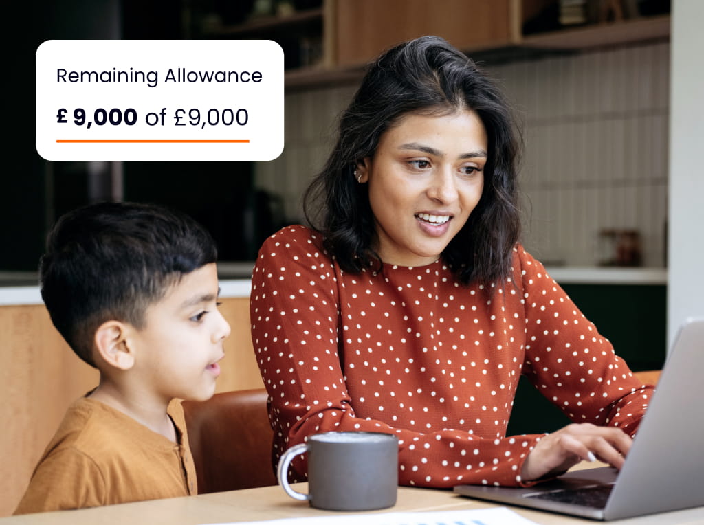 Young mother with son on laptop in the kitchen with sign showing £9000 JISA annual allowance