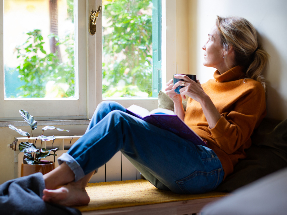 Woman staring at window with coffee 