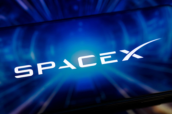 SpaceX logo against blue screen, Getty