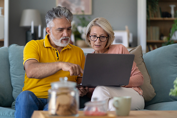 Couple sitting on sofa looking at fund data