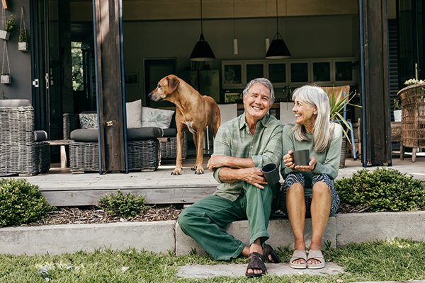 A couple with their dog sitting in a garden